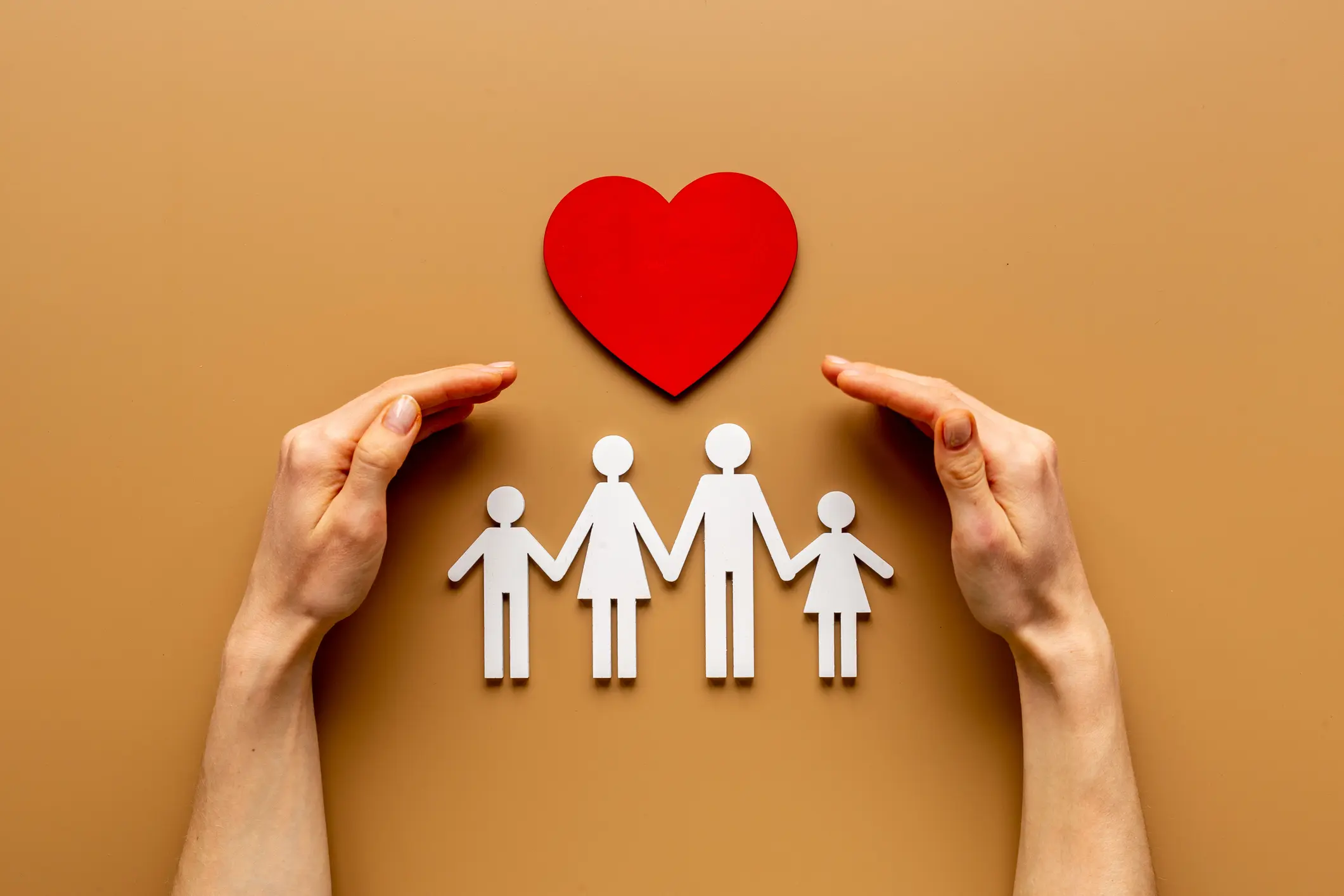 Hands holding family figure. Life and health insurance concept