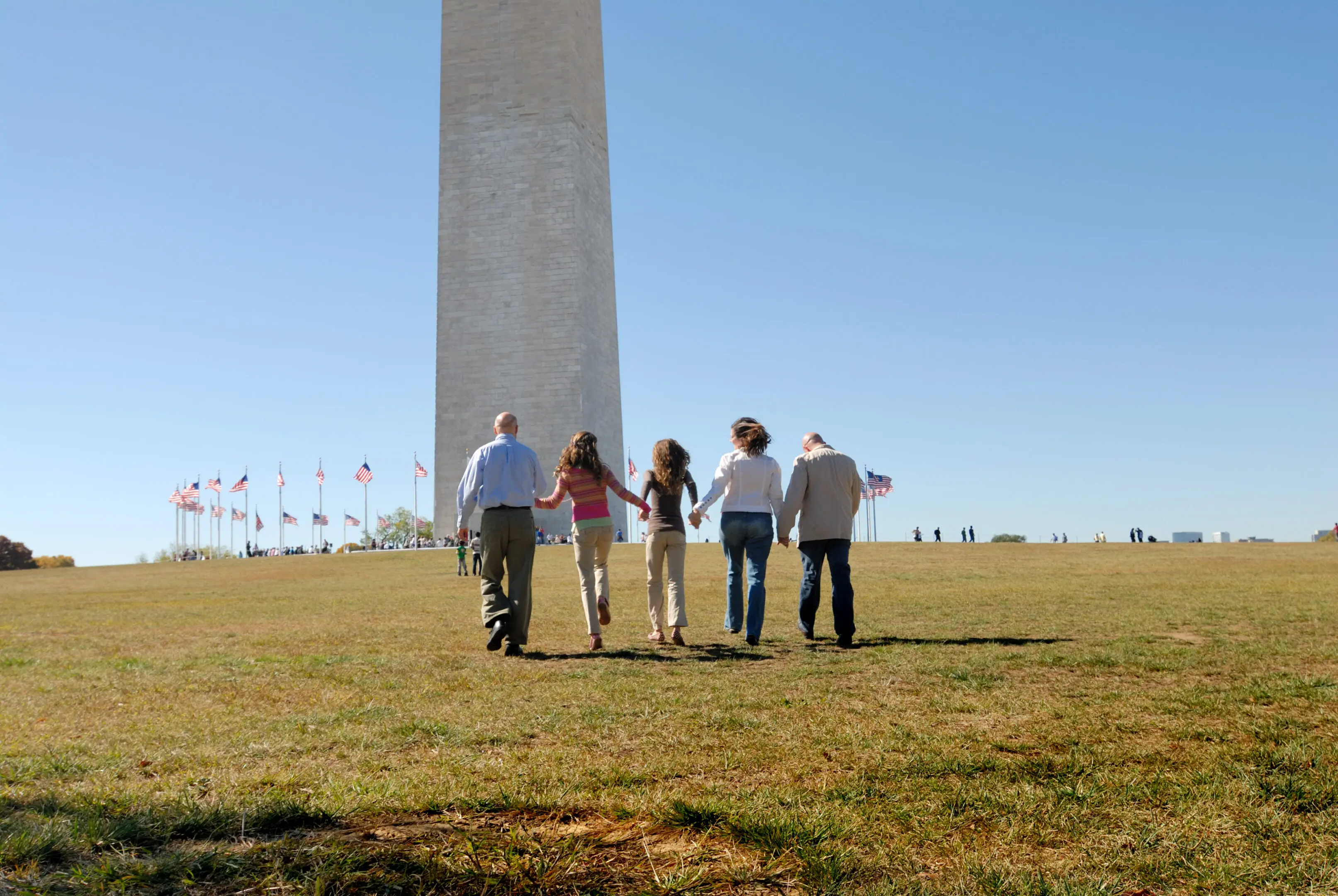 "Multi-generational family of five walk up hill toward the Washington Monument in Washington, D.C. Copyspace."